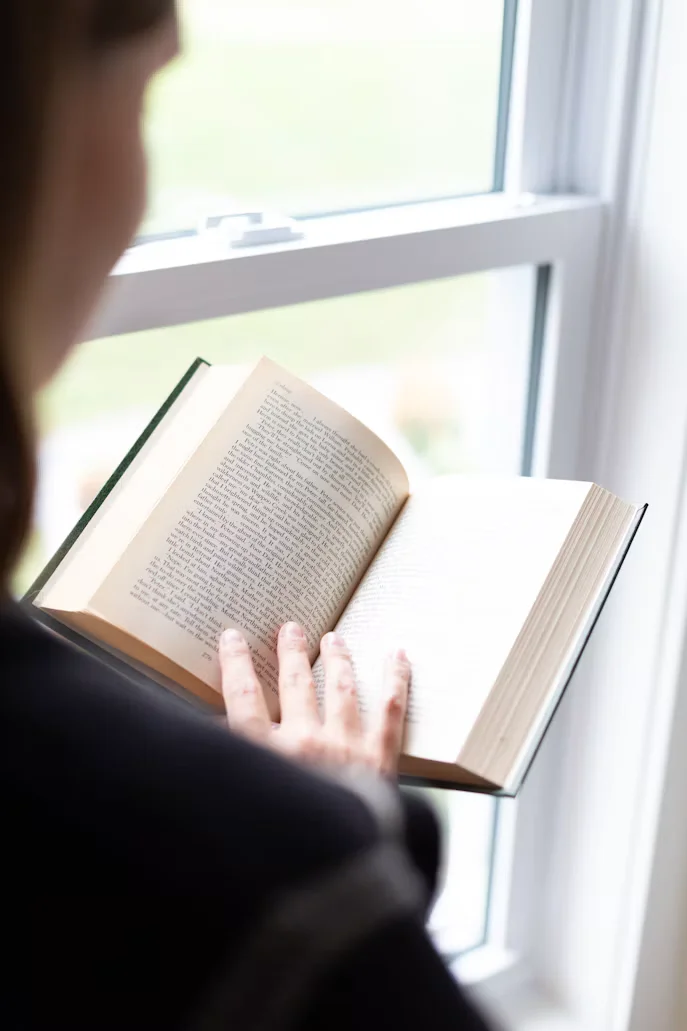 窓辺で本を読み、学ぶ様子